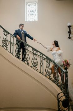 the bride and groom are walking down the stairs