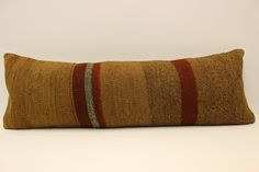 a brown and red striped pillow sitting on top of a white table