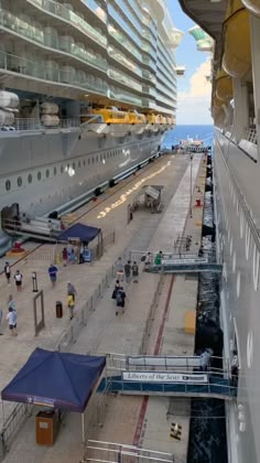 a cruise ship docked at the dock with people walking around