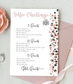 a pink and black confetti themed selfie challenge card next to a rose