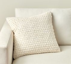 a close up of a white couch with a pillow on it's backrest