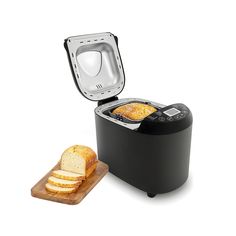 a toaster with slices of bread in it next to a slice of bread on a cutting board