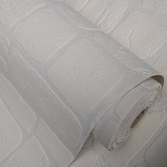 a roll of toilet paper sitting on top of a white wall