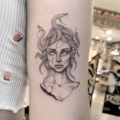 a woman's face and snake tattoo on the arm