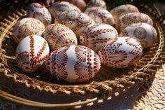 a basket filled with white and red decorated eggs