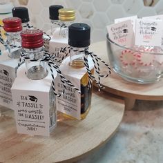 small bottles with labels on them are sitting on a table next to a glass bowl