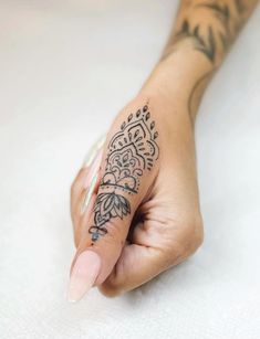 a woman's hand with a tattoo on her left arm and the other half of her finger