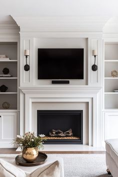 a living room with a fire place and bookcases on either side of the fireplace