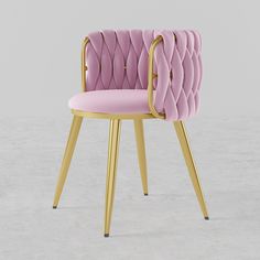 a pink chair sitting on top of a wooden table next to a white wall with a gold frame