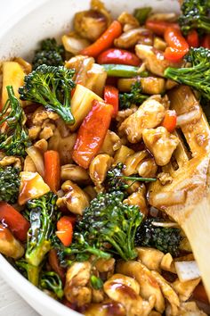 stir fry with chicken, broccoli and peppers in a white bowl