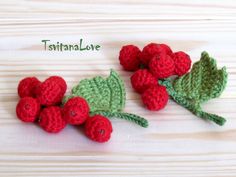 crocheted raspberries with leaves on wooden surface