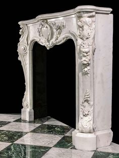 a white marble fireplace surround on a black and white checkered floor