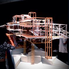 a model of a building on display with people looking at it