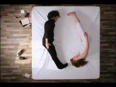 two people are laying on a bed together