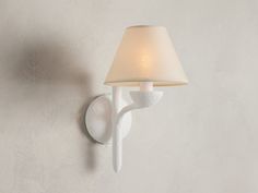 a white wall light with a shade on it