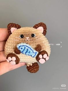 a small crocheted cat with a fish in it's mouth is shown