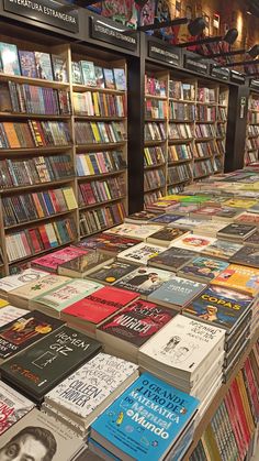 rows of books are lined up on the floor in front of a book store display