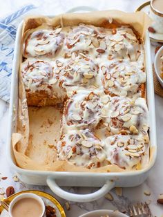 a casserole dish with almonds on top and coffee in the back ground