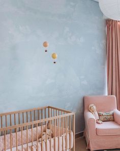 a baby's room with blue walls and pink furniture