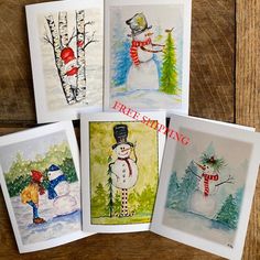 four cards with snowmen and trees on them, one has the word free standing