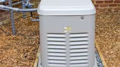 a large gray cooler sitting on top of a wooden pallet next to a brick wall