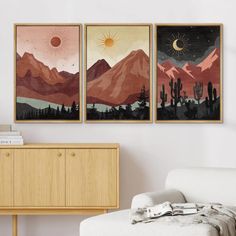 three paintings hang on the wall above a white couch