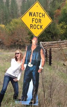 a man and woman standing in front of a sign that says watch for rock on it