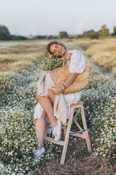 a woman sitting on a stool in a field