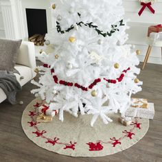 a white christmas tree with red and gold ornaments