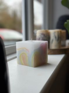 a candle sitting on top of a counter next to a window