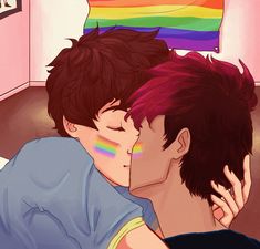 two young men kissing each other in front of a rainbow colored flag on the wall