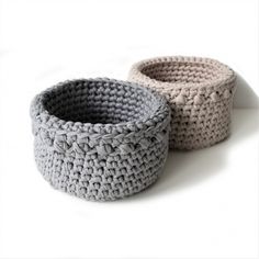 two crocheted baskets sitting next to each other