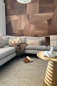 a living room with a sectional couch and pillows on the floor next to a coffee table