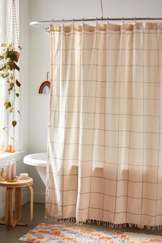 a bath room with a shower curtain and a rug