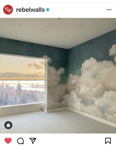 an empty room with a large window overlooking the city and clouds painted on the wall