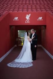 a bride and groom standing in front of an empty stadium