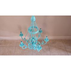 a blue chandelier with five candles on it in the middle of a room