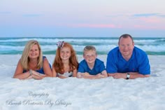 a family is laying in the sand at the beach