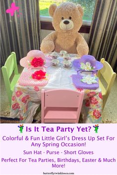 a teddy bear sitting at a table with tea cups