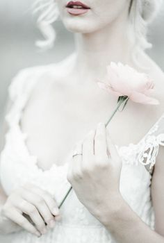 a woman holding a flower in her hand