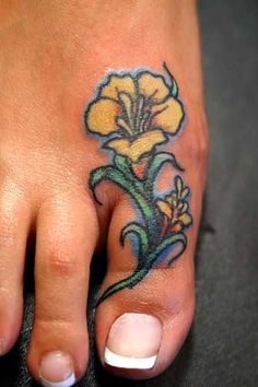 a foot with a yellow flower tattoo on it's left toe and bottom part