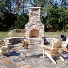 an outdoor fireplace with chairs around it