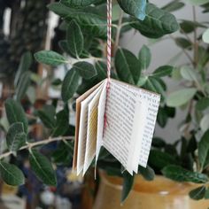 an open book hanging from a tree branch