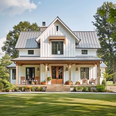 a large white house sitting on top of a lush green field