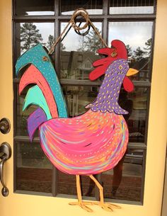 a colorful rooster standing in front of a door