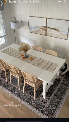 a dining room table with chairs and a rug on the floor in front of it