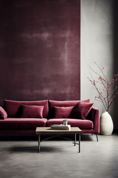 a red couch sitting in front of a white vase