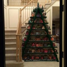 a christmas tree made out of legos in front of a staircase with ornaments on it