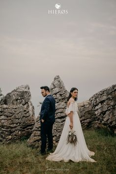 a man and woman standing next to each other on top of a grass covered field