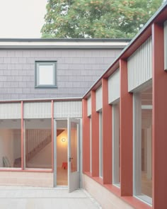 an outside view of a house with red and white walls, windows, and stairs